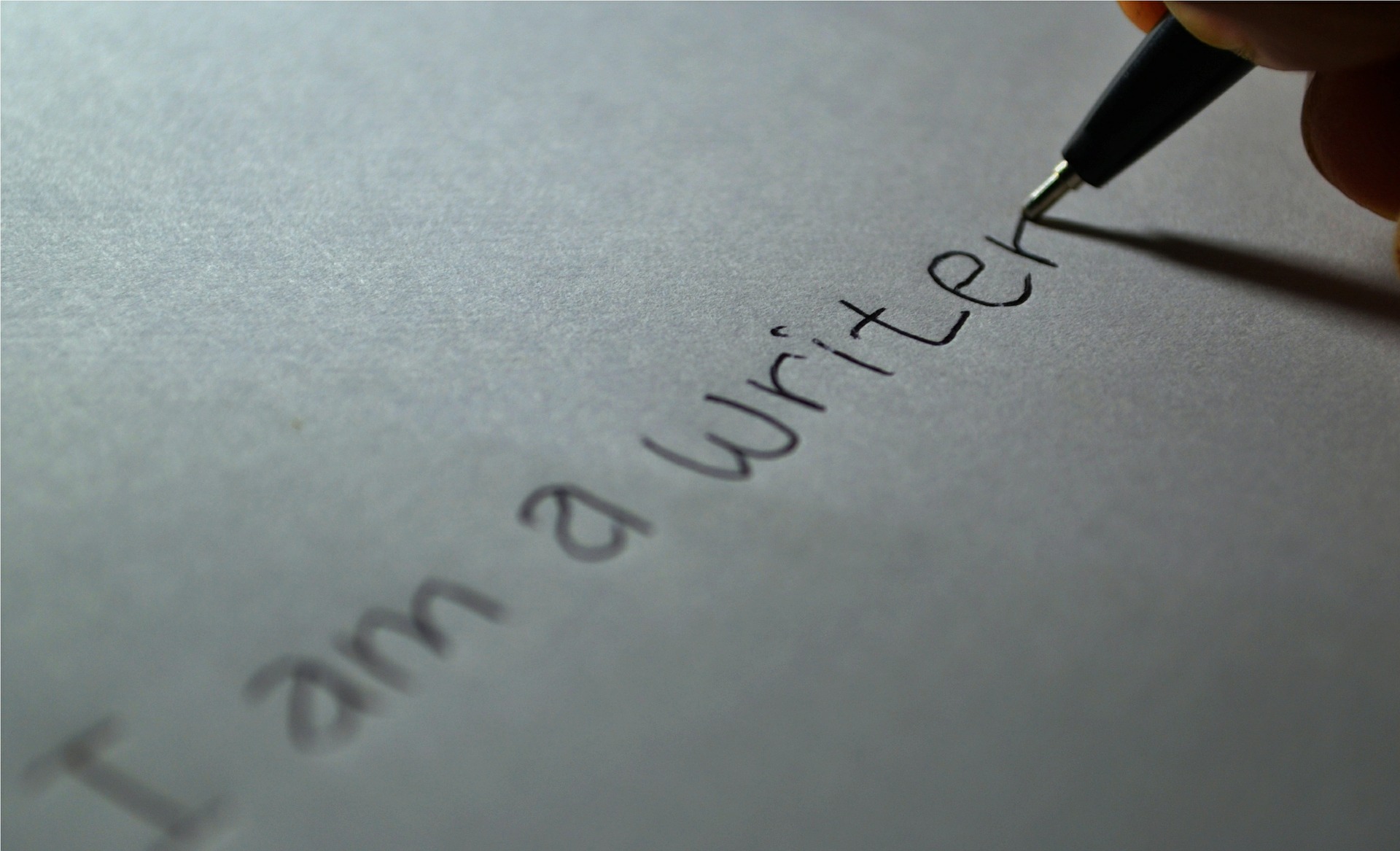 Photograph of person writing "I am a writer."