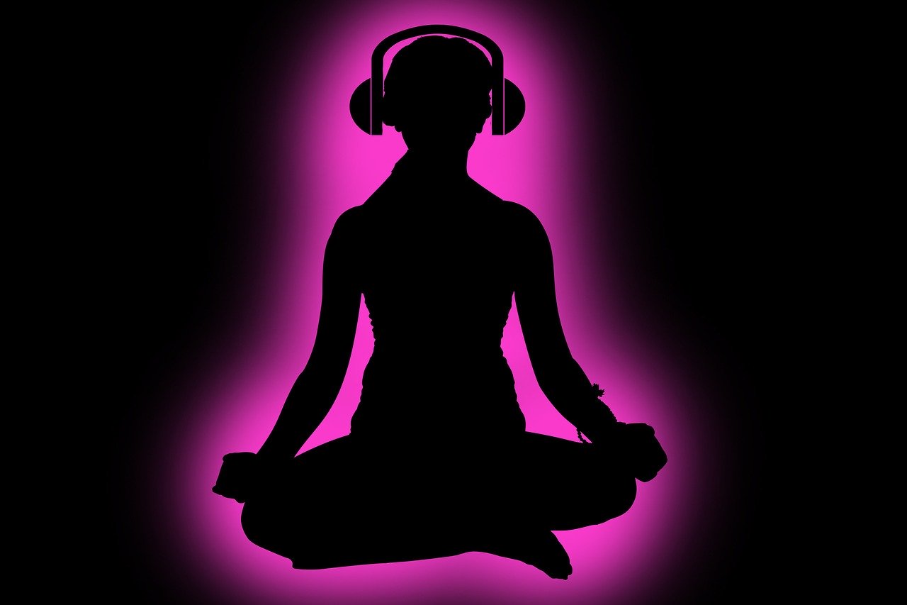 A black background with a silhouette of a person sitting cross-legged with earphones on, and a pink glow is surrounding their body.