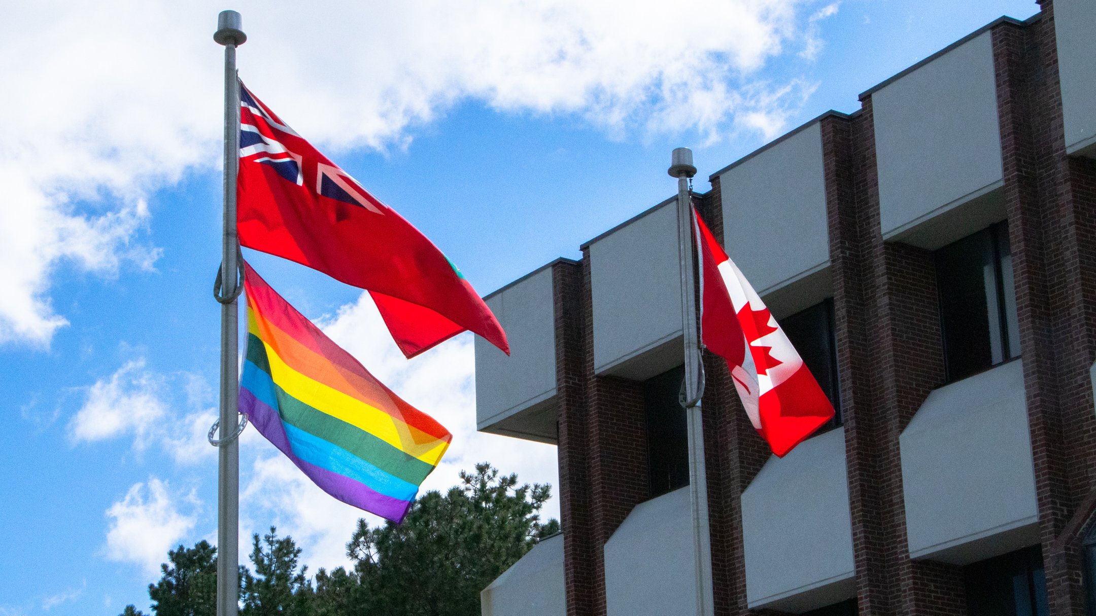 Pride flag flying alongside the Ontario and Canadian flags.