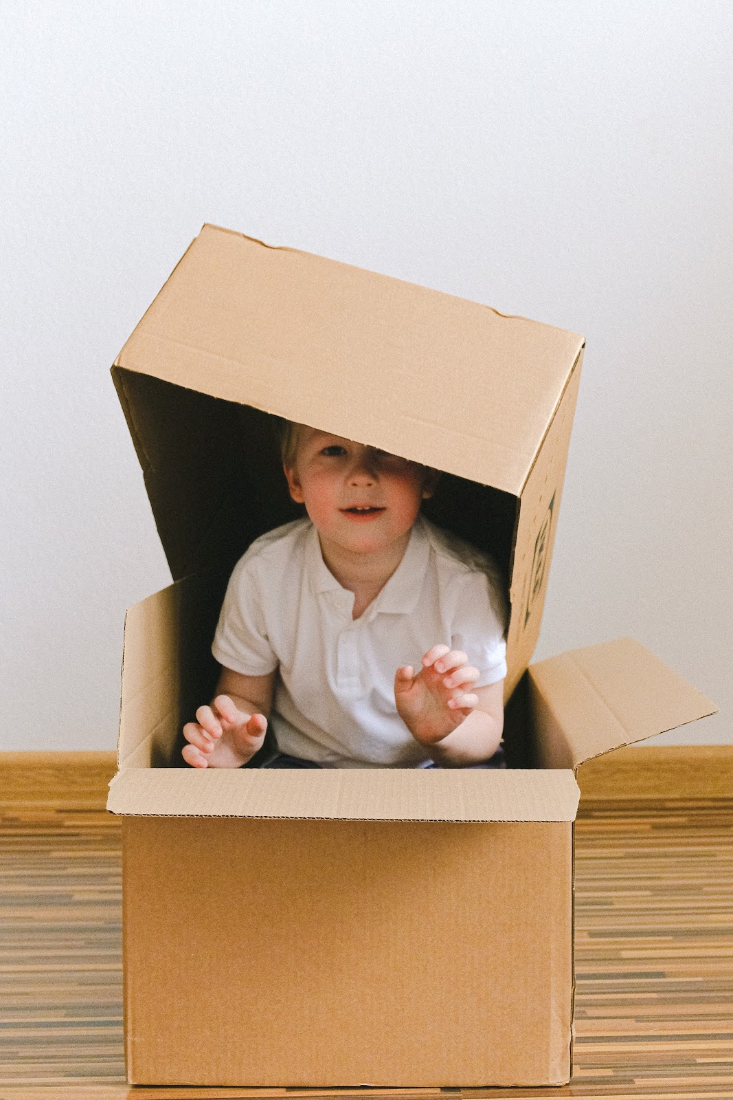 boy playing in a cardboard box