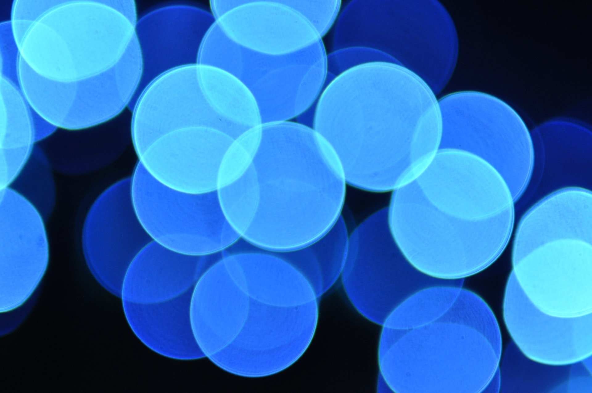 Transparent blue circles overlapping one another on a black background.